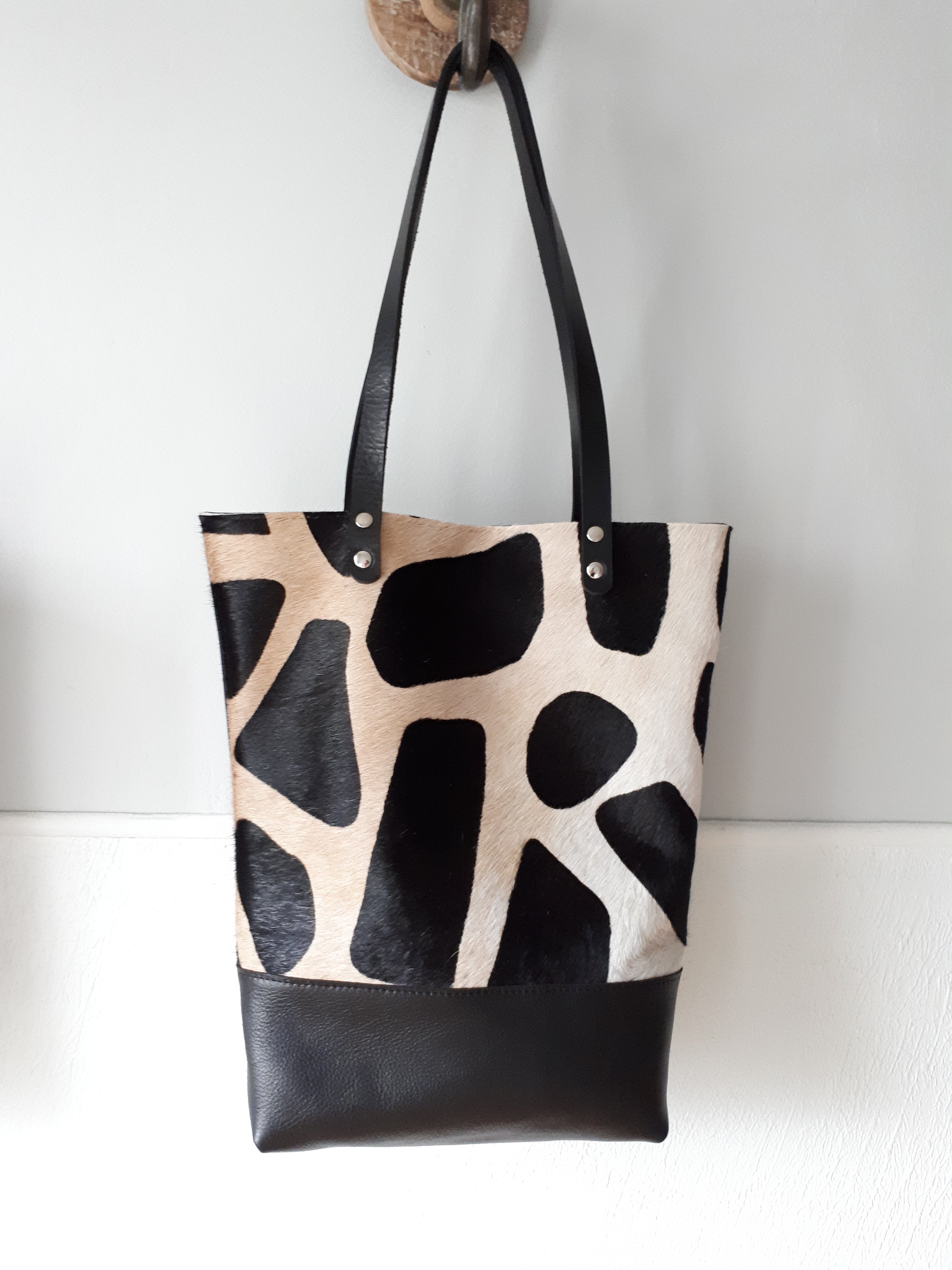 Zwarte leren tas met koeienvacht in giraffe print