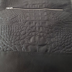 Zwarte leren tas met een krokodillenprint.